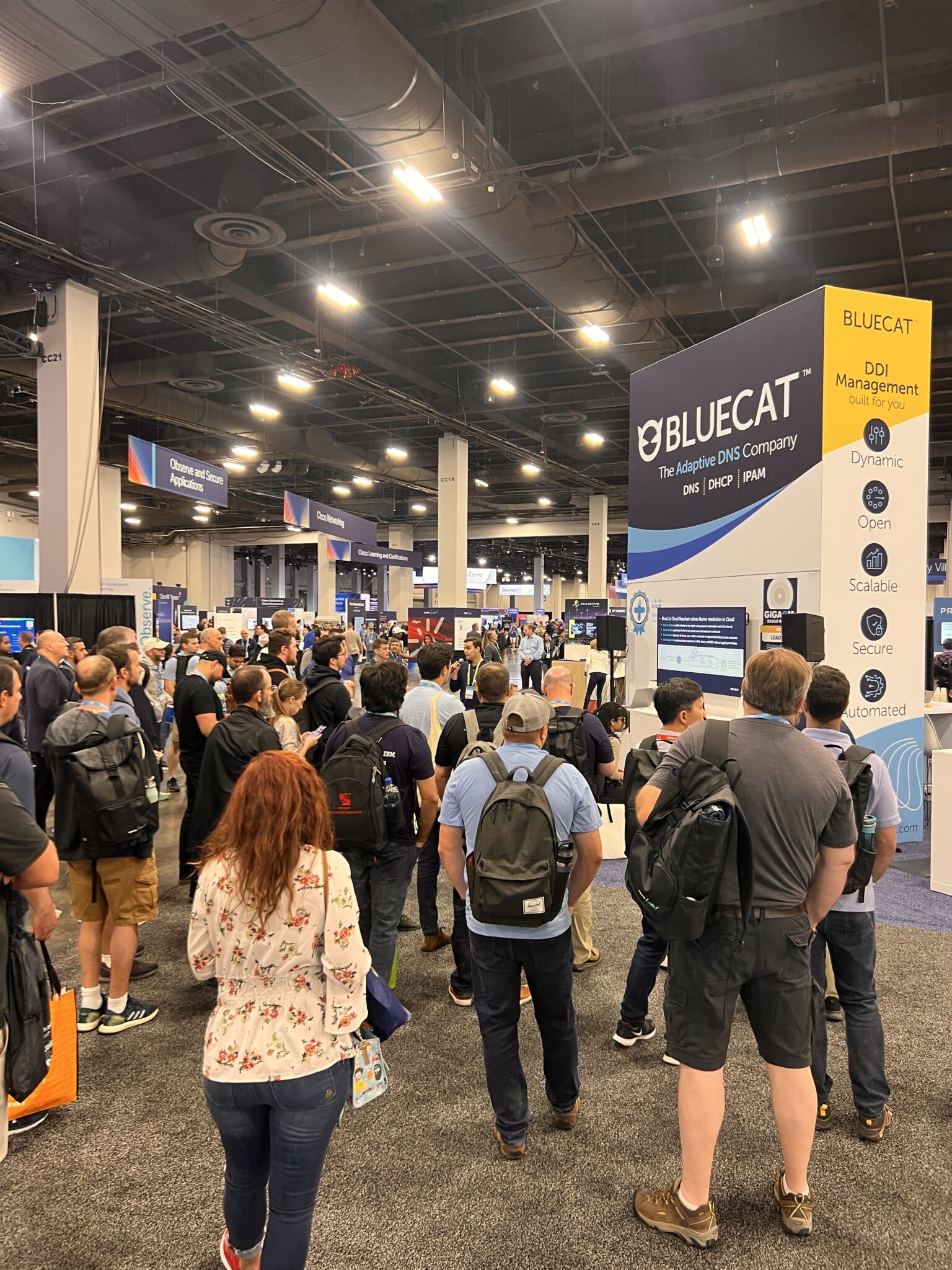 A crowd gathered for a booth presentation at BlueCat's booth on the World of Solutions floor at Cisco Live 2023
