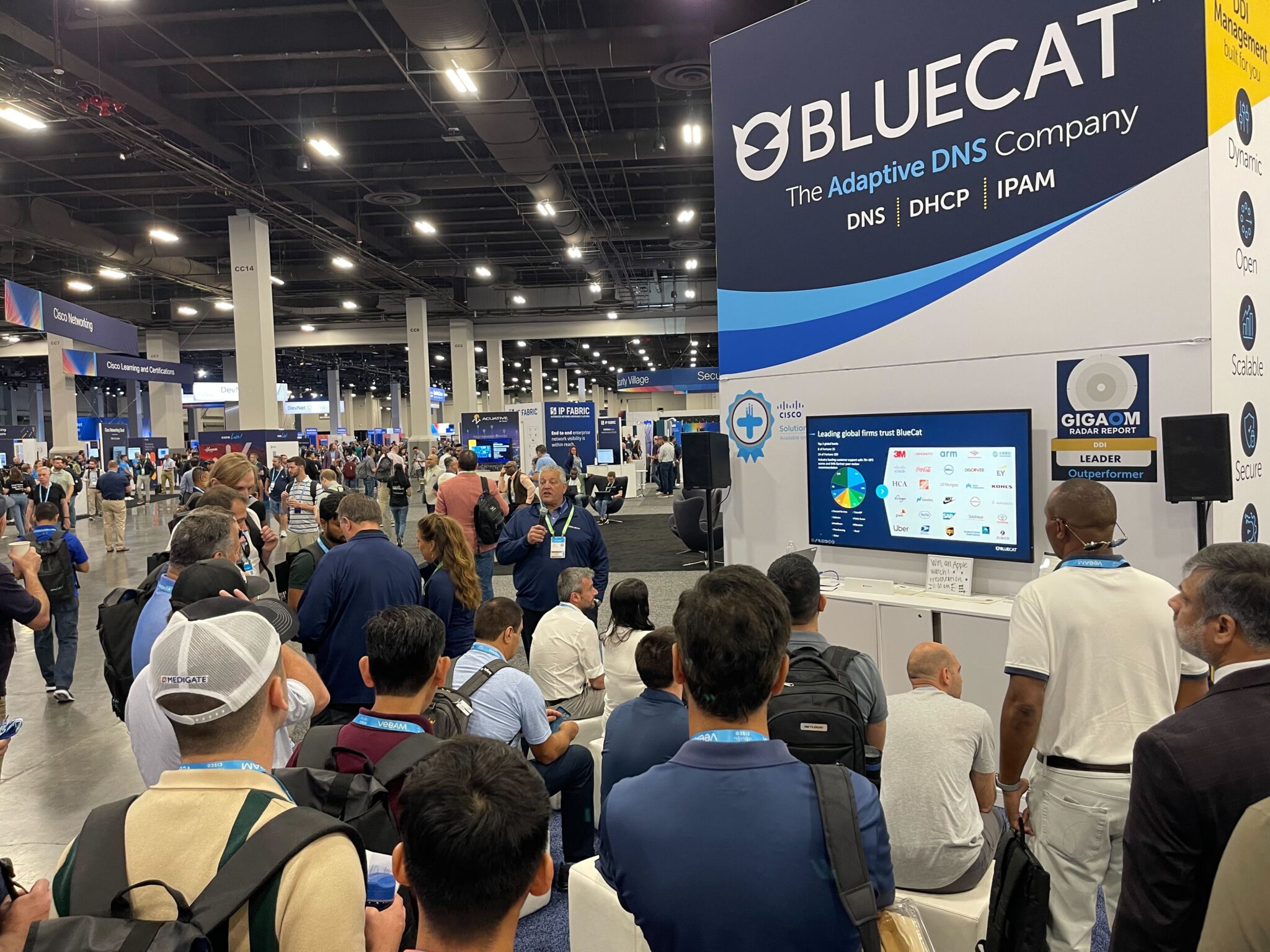 A crowd gathered for a booth presentation at BlueCat's booth on the World of Solutions floor at Cisco Live 2023